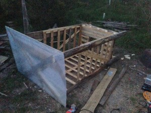 Préparation au sol d'une cabine déplaçable, pour former des buttes de culture. Ici avec une "caisse" récupérée en jardinerie, des dosses et bois de récup. La palette a été percée, et renforcée.